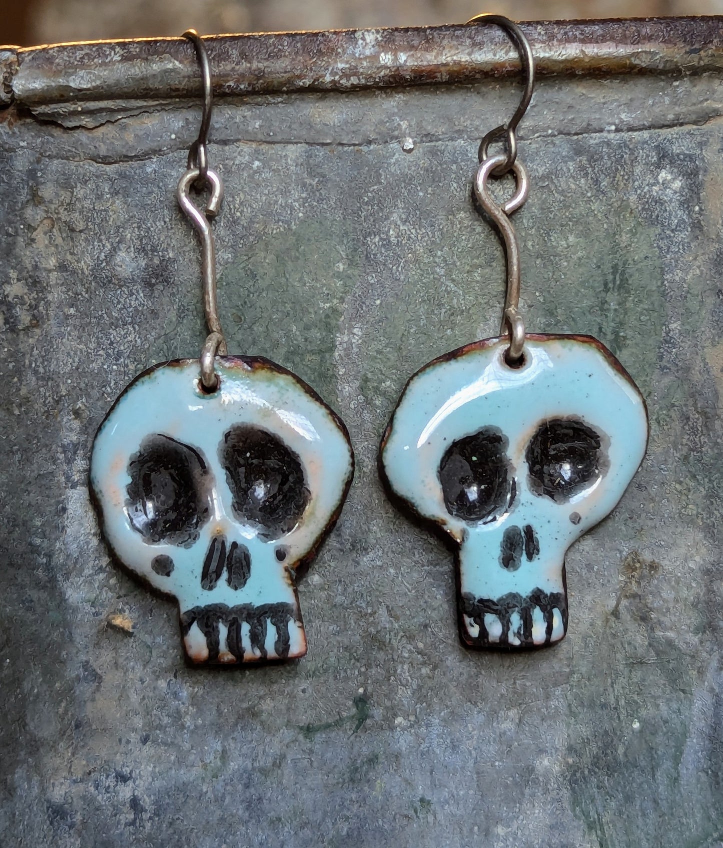 Super cute Skully earrings. Enameled copper with sterling silver accent wire.