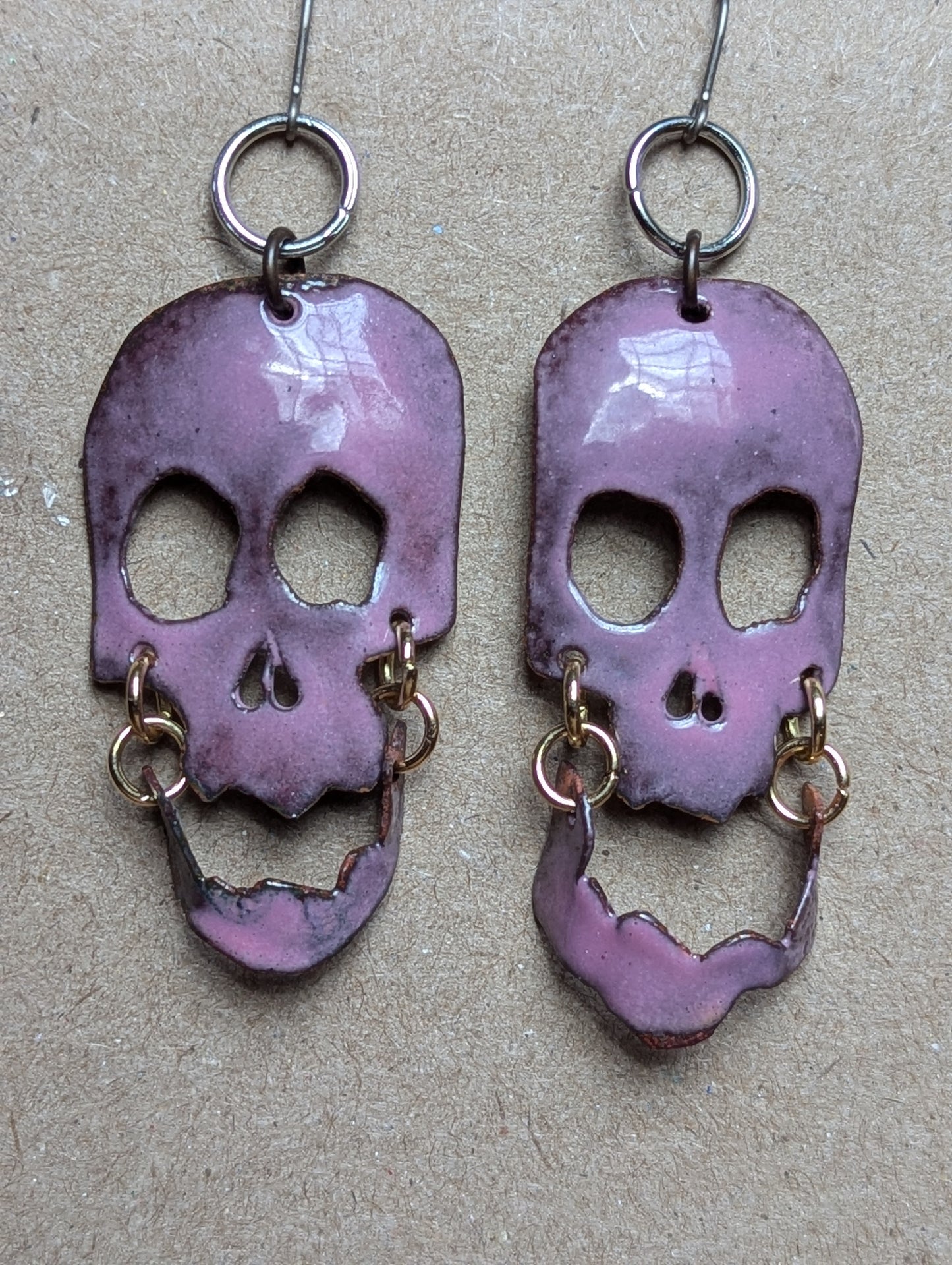 Skully earrings with halo and flair for days.  Enameled hand formed copper with moving jaws